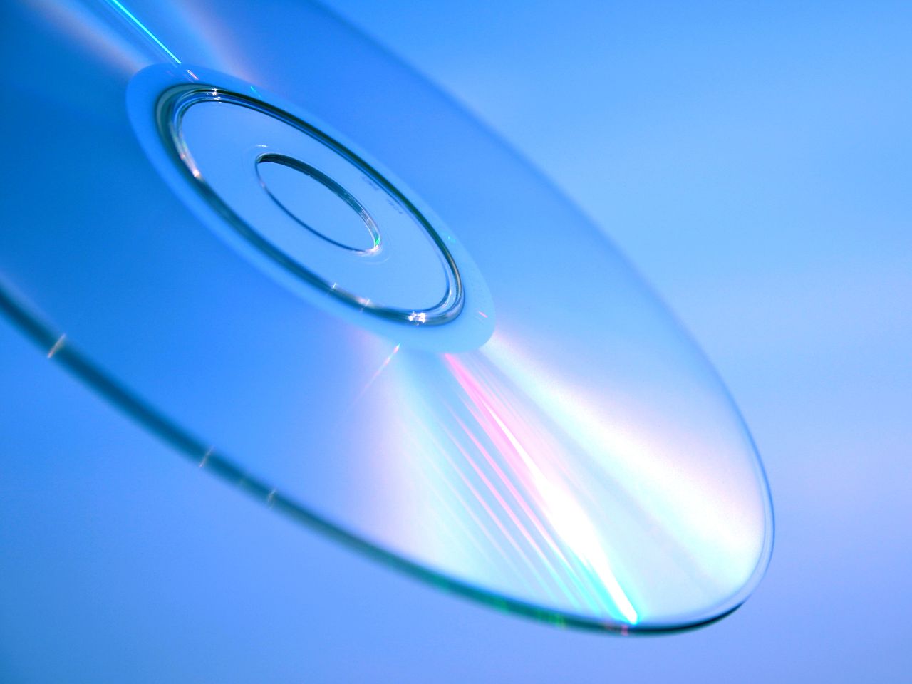 La surface de lecture d'un seul CD, irisée sous une lumière bleue. Quoi qu'il l'ait dimensionné, l'objet lui-même est d'une beauté discrète. Crédit : happyend / Pexels (libre d'utilisation)