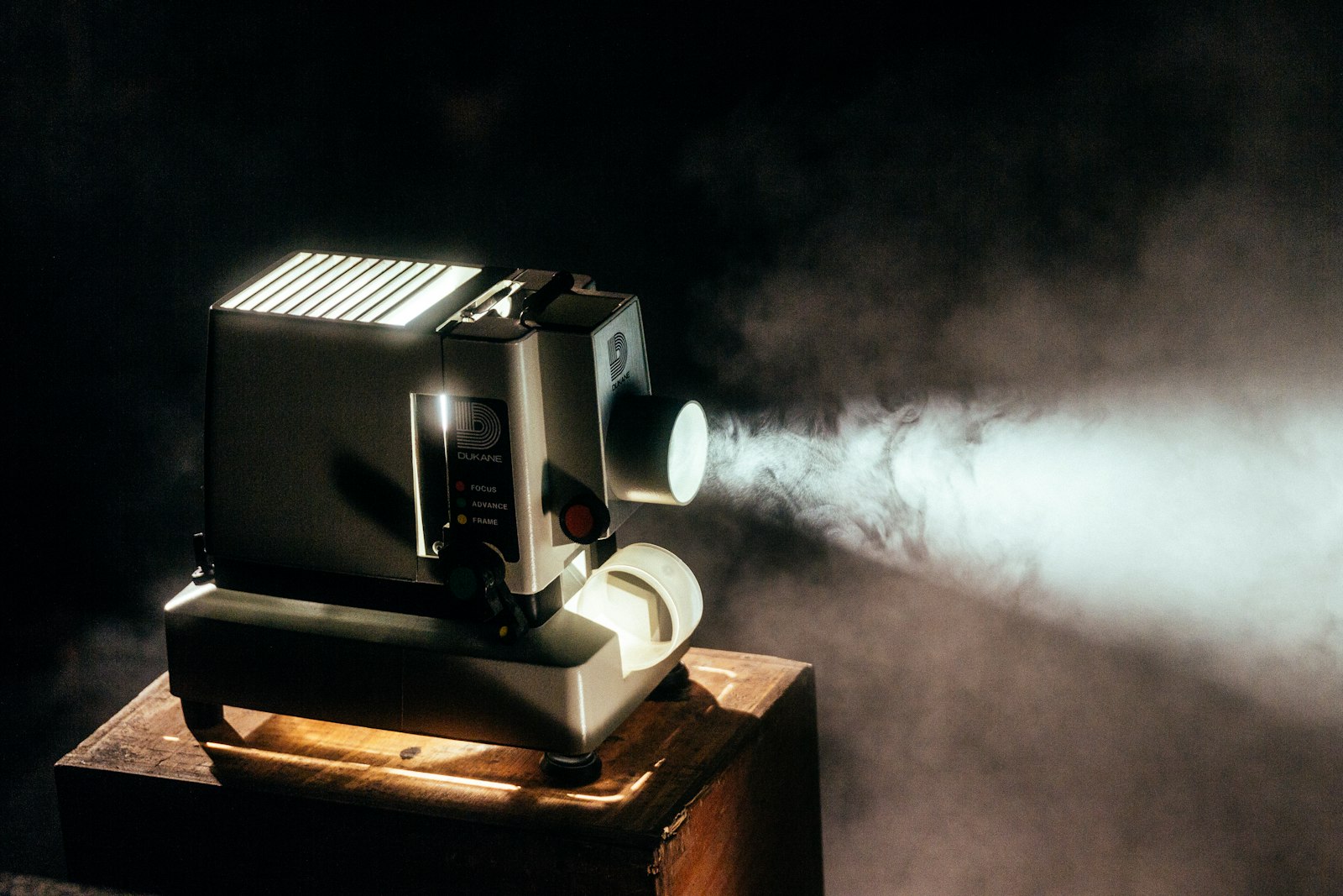 Un projecteur traçant son faisceau dans une salle obscure — la machine qui, depuis 1927, fait défiler la pellicule à 24 images par seconde, sans faillir. Photo : Unsplash.