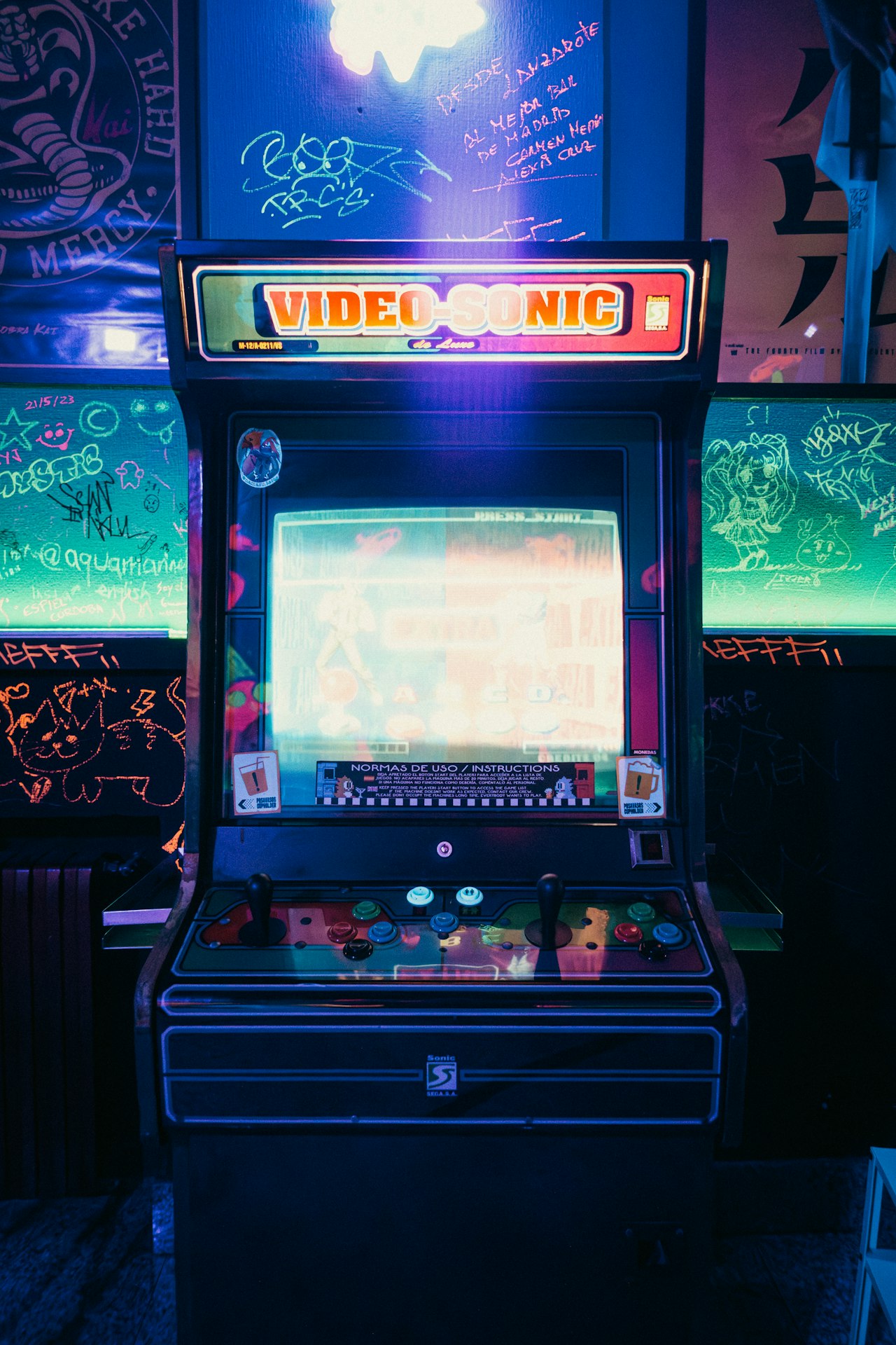Une borne d'arcade vintage baignée de néons — l'ère du génie à cycles comptés qui a rendu la 3D temps réel possible — Crédit : Brunno Tozzo / Unsplash