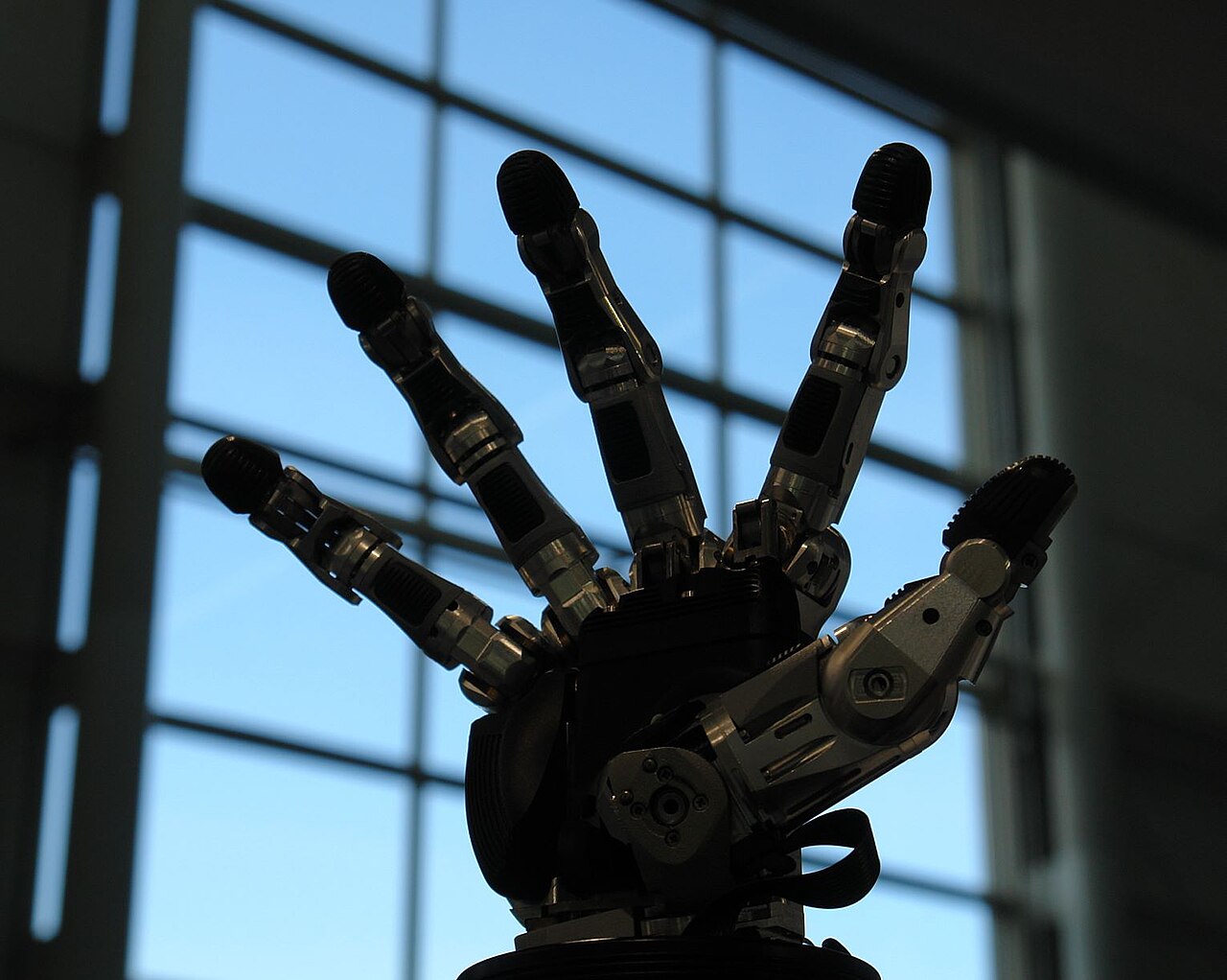 Une main de préhension robotique à plusieurs doigts. Les capteurs tactiles transforment une prise maladroite en une prise assurée. — Crédit : NearEMPTiness, Wikimedia Commons (CC BY-SA 4.0)