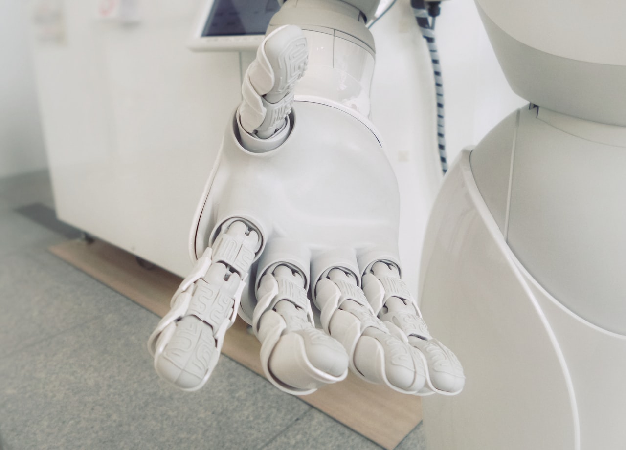 Gros plan d'un bras robotique blanc — le genre de bras qui gagne en finesse grâce au sens du toucher. — Crédit : Franck V. sur Unsplash (Licence Unsplash)