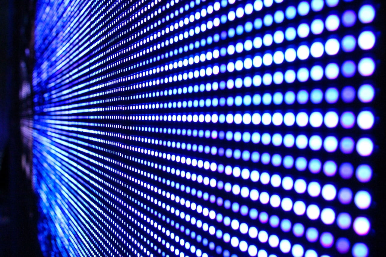 Un mur de pixels LED en gros plan : des milliers de minuscules lumières, l'ingrédient brut d'un monde artificiel tout entier — Crédit : Justin Lane (Unsplash, libre d'usage)