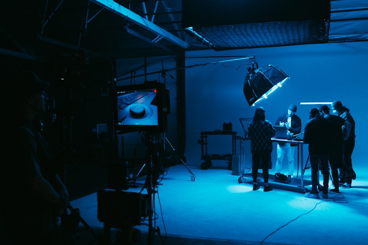 Sur un plateau de production virtuelle, l'équipe travaille dans la lueur de l'écran — l'arrière-plan n'est plus quelque chose qu'on ajoute après coup, mais de la lumière dans la pièce — Crédit : Jakob Owens (Unsplash, libre d'usage)