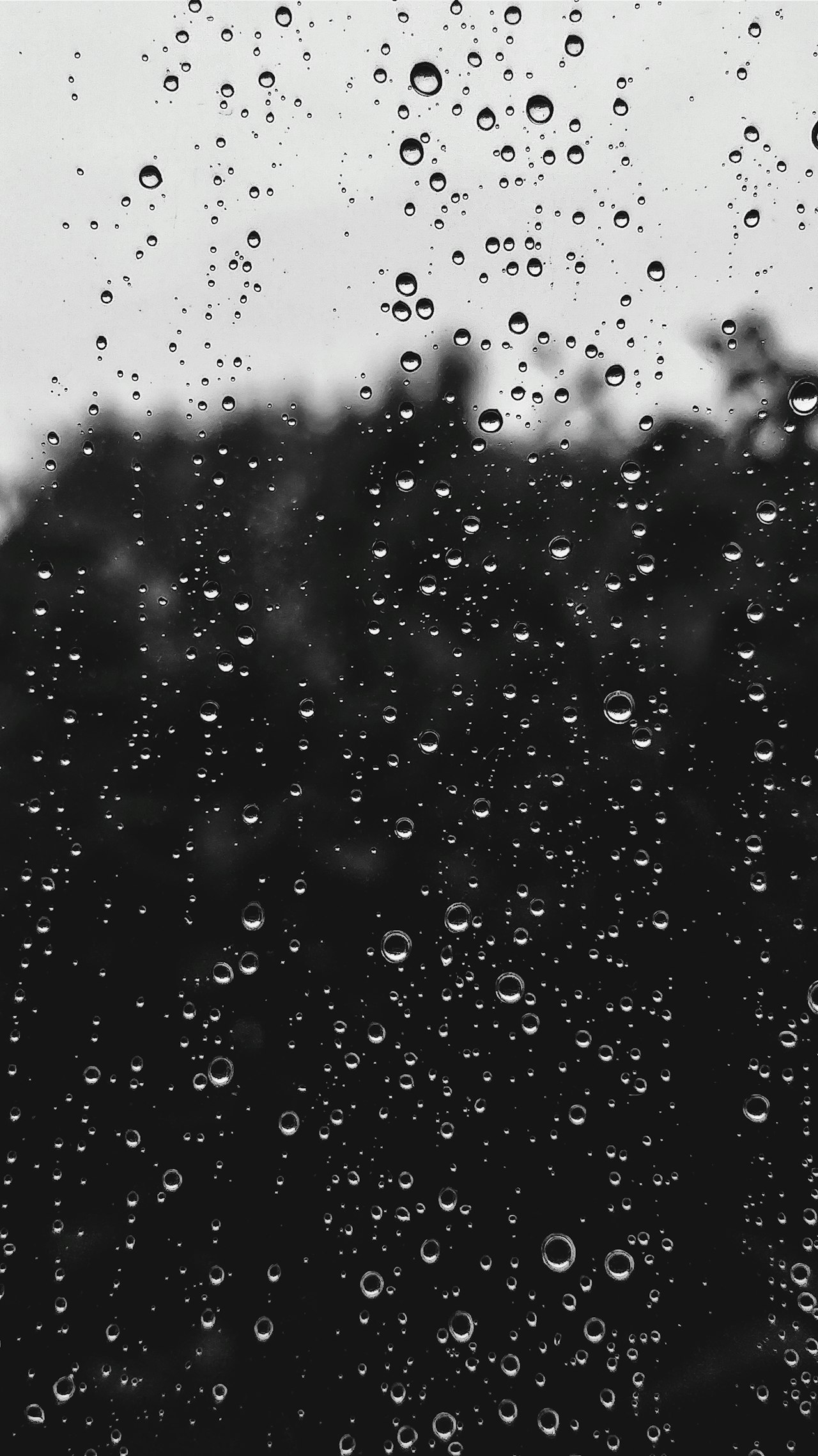 De la pluie sur une vitre. Chaque impact sur un sol poreux emprisonne une bulle d'air qui remonte en pétillant et éclate en une fine brume d'aérosols porteurs d'odeur. Crédit : Valentin Müller / Unsplash (libre d'usage).