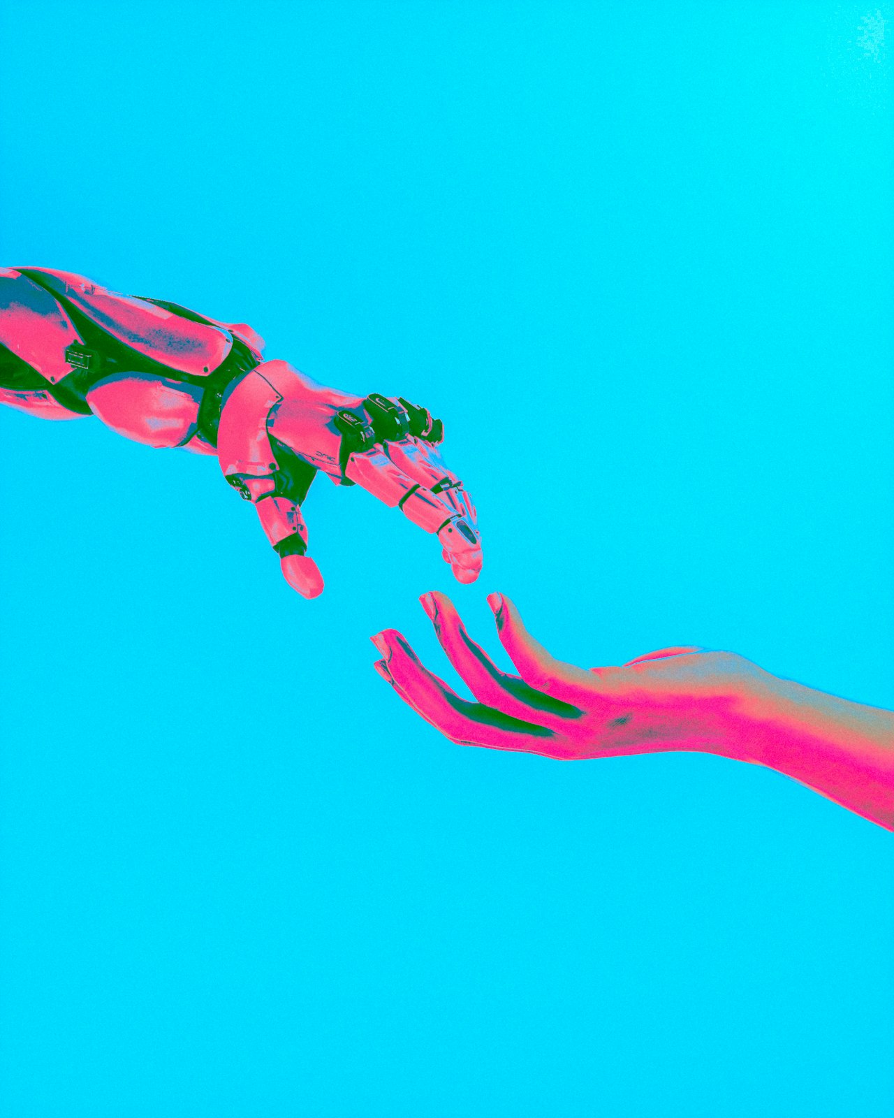 Une main humaine et une main robotique qui se tendent l'une vers l'autre — l'écart que les interfaces cerveau-machine sont en train de combler en silence. Crédit : Cash Macanaya / Unsplash (libre d'utilisation)