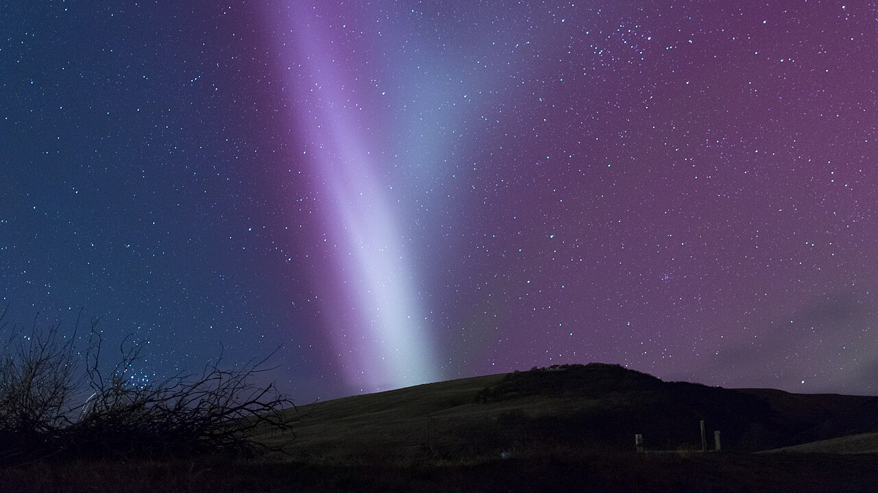 Un ruban violet de STEVE s'étirant dans le ciel nocturne au-dessus d'une aurore verte — Crédit : The Modern Polymath (CC BY 4.0)