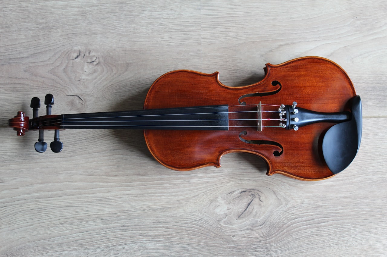 Un violon moderne posé sur du bois nu — dans les tests à l'aveugle, des oreilles expertes n'ont pas su distinguer de façon fiable un instrument neuf de ce type d'un Stradivarius inestimable — Crédit : Unsplash (libre d'utilisation)