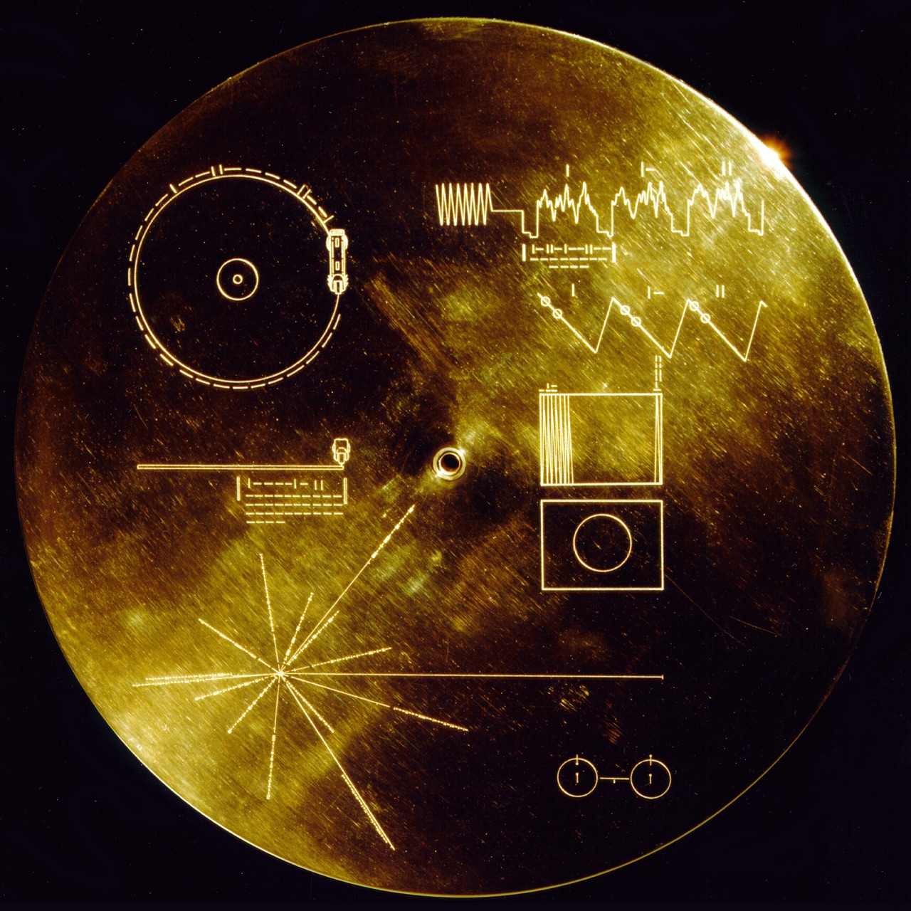 La pochette du Disque d'or des Voyager — un boîtier en aluminium doré gravé de schémas qui expliquent, par l'image et le binaire, comment lire le disque et où se trouve la Terre. Crédit : NASA/JPL (Domaine public)